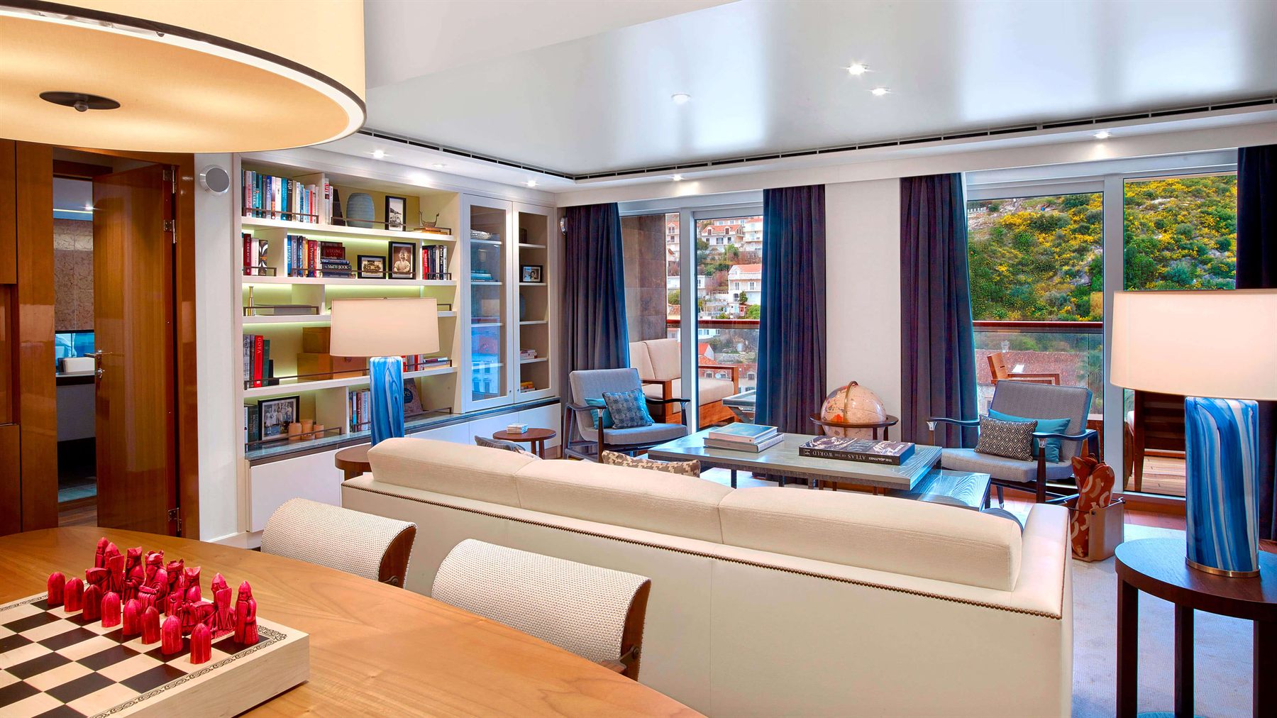 The dining table and lounge of a Crystal Cruises owner’s suite with wraparound windows