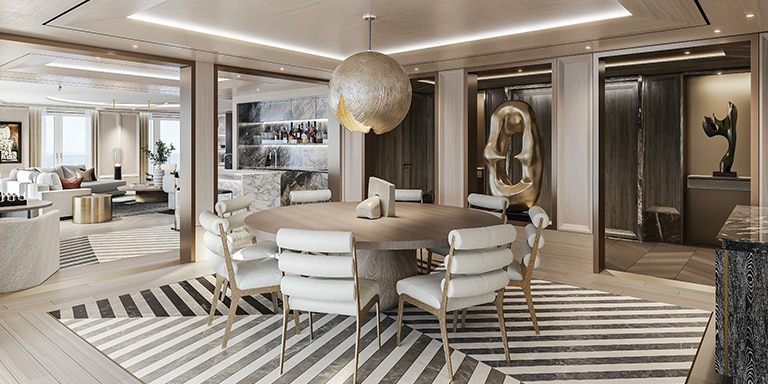 The dining area of a cruise-ship suite with a round table, pendant lamp and modern sculpture
